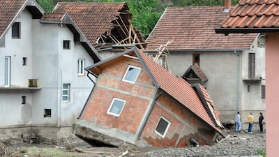 People standing near damaged houses after flooding in Krupanj, 150km south-east of Belgrade, Serbia. Dragan Karadarevic / EPA