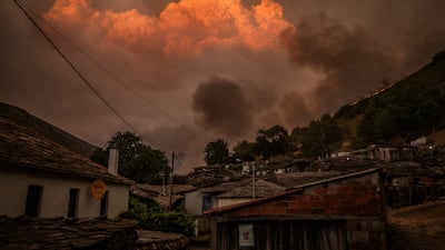Smoke rises from a wildfire looming towards the village of Vilarmel, in Galicia, north-western Spain. Reuters
