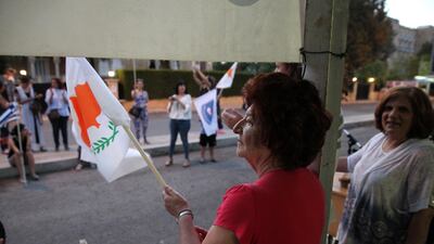 A woman waves a Cypriot flag during a protest against positions put forward by Greek Cypriot president Nicos Anastasiades in reunification talks, at the Ledra Palace checkpoint in the UN-controlled buffer zone in Nicosia on July 6, 2017. Yiannis Kourtoglou / Reuters