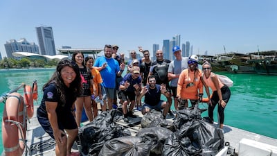 Dive volunteers with the collected bags of trash at Abu Dhabi Dhow Harbour. Victor Besa / The National