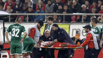 Olympiakos' Michael Olaitan of Nigeria leaves the pitch on a stretcher during a Greek League match against Panathinaikos at Georgios Karaiskakis stadium, in Piraeus port, near Athens, on Sunday. Thanassis Stavrakis / AP Photo