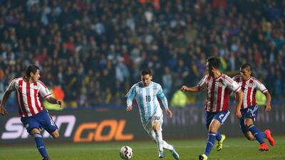 Argentina's Lionel Messi dribbles through Paraguay defenders during the Copa America semi-final on Tuesday night in Concepcion. Andre Penner / AP