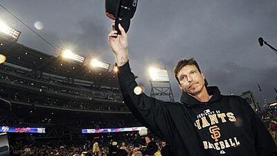 The San Francisco Giants starting pitcher Randy Johnson tips his cap to the crowd after earning his 300th career win.