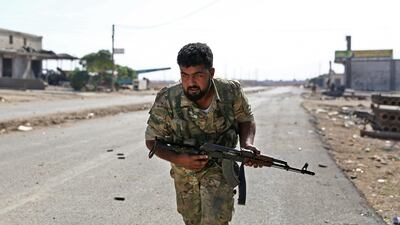 A Turkish-backed Syrian fighter runs along a road in Syria's northeastern town of Ras al-Ain in the Hasakeh province along the Turkish border as Turkey and its allies continue their assault on Kurdish-held border towns in northeastern Syria. Ras al-Ain, is the main remaining flashpoint along the border where Kurdish-led SDF have been putting up stiff resistance against Turkish air strikes and shelling for almost a week. AFP