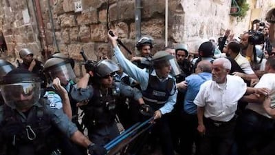 An Israeli policeman (left) shouts at Palestinian demonstrators near Lion's Gate in Jerusalem's Old City, as clashes take place at a nearby compound known to Muslims as Noble Sanctuary and to Jews as Temple Mount.