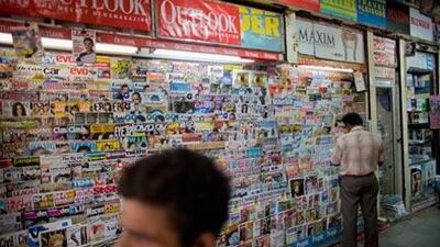 A customer looks at magazines at a news-stand in New Delhi, India.
