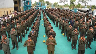 Indian workers take part in a basic yoga exercise at H Cube Industries ahead of International Yoga Day, at Vasna Buzarg village. Sam Panthaky / AFP