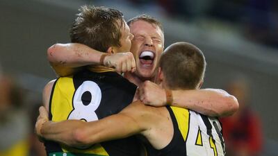 AFL player Josh Caddy of the Richmond Tigers, centre, celebrates his winning goal against and the Melbourne Demons at Melbourne Cricket Ground. Michael Dodge / AFL Media / Getty Images