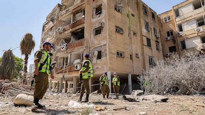 Israeli security forces gather outside a building hit by an Iranian missile in the central city of Holon. AFP