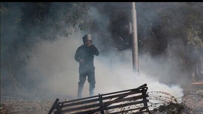 A riot police covers his face from tear gas during clashes with anti-Morsi protesters at Tahrir Square in Cairo November 27, 2012. Ahmed Jadallah / Reuters