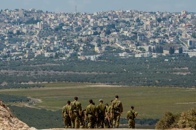 Israeli soldiers patrol a dirt path near the Havat Emek Dotan illegal settlers' outpost overlooking the Palestinian town of Ya'bad. Getty Images