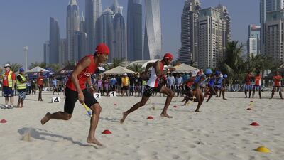 Lifeguards show a clean pair of heels during the relay race at Le Royal Meridien Beach Resort and Spa. Jeffrey E Biteng / The National