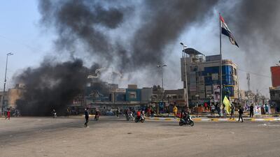 Iraqi protesters are pictured next to burning tyres during clashes with police during anti-government demonstrations in the city of Nasiriyah in the Dhi Qar province in southern Iraq. AFP