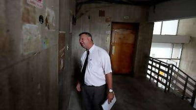 Norm Labbe, the managing director of the Emirates Institute for Health and Safety, inspects a substandard fire alarm panel in a residential building in Abu Dhabi.