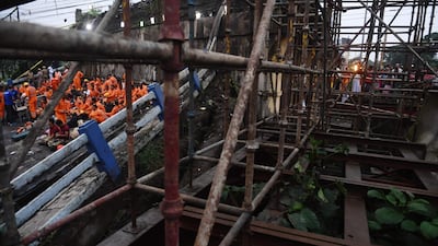 Exhausted rescue personnel rest as colleagues carry on a search operation. AFP