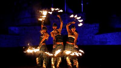 Members of PyroCeltica pose in front of Edinburgh Castle in advance of Edinburgh's Hogmanay torchlit procession. Reuters