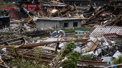 Workers survey the devastation following days of heavy rain and flooding in the village of Kuma, Kumamoto prefecture, Japan. AFP