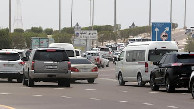 Police divert traffic away from Abu Dhabi and down Al Faya Street towards Dubai on July 15. At least hundreds had queued to access a new laser testing facility that can give commuters results to a Dh50 test in five minutes, allowing them to enter the capital. Pawan Singh / The National