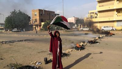 A Sudanese protester waves a national flag during a rally in the capital Khartoum to condemn the "massacre" of five demonstrators including four high school students at a rally in a central town of Al-Obeida. AFP