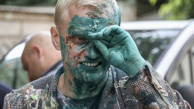 Vitaliy Shabunin wipes his face after he was splashed with a green substance during a rally in Kiev. Reuters