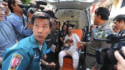 A woman is helped by members of a rescue team after being injured when the engine of a commuter boat exploded at Wat Thepleela pier in Bangkok on March 5, 2016. Narong Sangnak / EPA