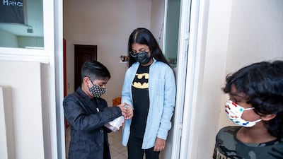 Ayesha, 10, sanitises her hands before borrowing books from Ayaan's library.
