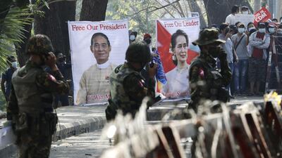 Soldiers stand guard in front of banners calling for the release of Myanmar State Counselor Aung San Suu Kyi and President Win Myint during a protest outside the Central Bank in Yangon, Myanmar. EPA
