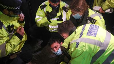 Police officers detain a man during the protests in London. Reuters