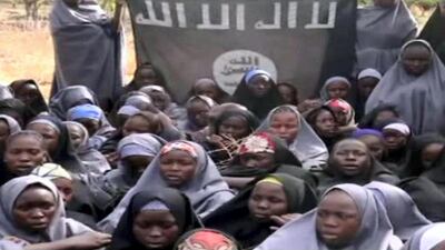 A screengrab taken on May 12, 2014, from a video released by Nigerian Islamist extremist group Boko Haram obtained by AFP shows girls wearing the full-length hijab holding a flag reading "There is no god, but Allah" and "Mohammed is Allah's prophet" at an undisclosed rural location. Boko Haram released a new video on claiming to show the missing Nigerian schoolgirls, alleging they had converted to Islam and would not be released until all militant prisoners were freed. A total of 276 girls were abducted on April 14 from the northeastern town of Chibok, in Borno state, which has a sizeable Christian community. Some 223 are still missing. AFP PHOTO / BOKO HARAM RESTRICTED TO EDITORIAL USE - MANDATORY CREDIT "AFP PHOTO / BOKO HARAM" - NO MARKETING NO ADVERTISING CAMPAIGNS - DISTRIBUTED AS A SERVICE TO CLIENTS (Photo by HO / BOKO HARAM / AFP)