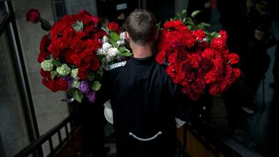 A funeral steward carries flowers laid by the coffin of regional parliament member Vyacheslav Markin, in Odessa, Ukraine. Markin, who was known for speaking out against the government in Kiev, was buried on Monday while about 300 pro-Russian supporters shouted ‘Hero, hero!’ Markin died Sunday from burn wounds sustained in Friday’s fire. Vadim Ghirda / AP Photo