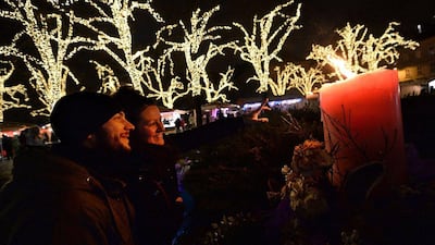 Hungary: A woman points at a candle on a giant Advent wreath during a Christmas market on the Deak square in Budapest. AFP Photo / Attila Kisbenedek
