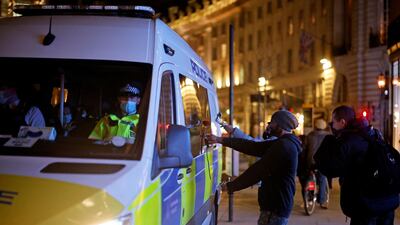 A protestor places a single rose on the door handle of a Police van in London. AFP