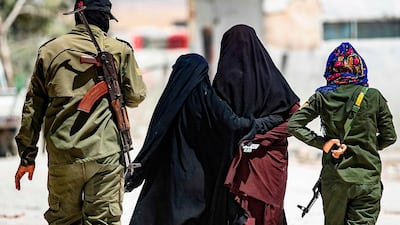 An internal security patrol escorts women, reportedly wives of ISIS fighters, in the Al Hol camp in eastern Syria. AFP