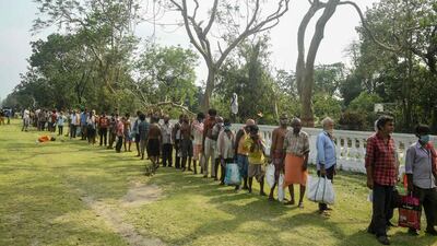 Migrant labourers queue to collect food distributed by locals at a roadside last month in Kolkata. Dibyangshu Sarkar / AFP