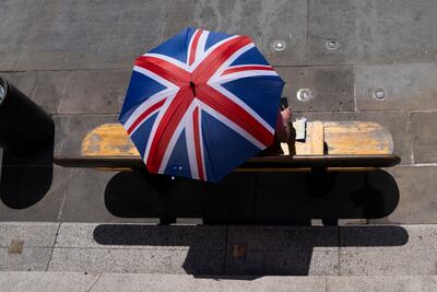 A couple cover themselves with an umbrella to avoid the heat in Trafalgar Square earlier this month. Reuters