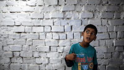 Eight-year-old Abhi, who suffers from mental and physical disabilities, plays outside his house at a slum in Bhopal.