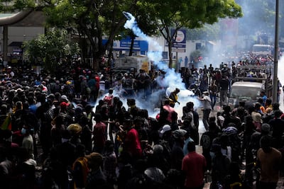 Protesters throw back tear gas canisters as they rally outside Prime Minister Ranil Wickremesinghe's office in Colombo on Wednesday. AP