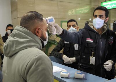 Egyptian Quarantine Authority employees scan body temperature for incoming travellers at Cairo International Airport. AFP