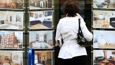 A woman looks at properties for sale in the window of an estate agent in central London. Reuters