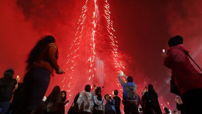 People watch as Dubai celebrates the New Year with a light and sound extravaganza at midnight at the Burj Khalifa, the world’s tallest tower, on January 1, 2015. KARIM SAHIB / AFP