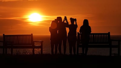 Early risers take pictures of the sunrise at Tynemouth Pier on England's North East coast. AP