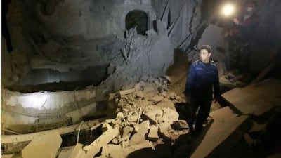 A police officer looks at a damaged building at the High Commission for Children in Tripoli which the Libyan government said was caused by coalition air strikes.