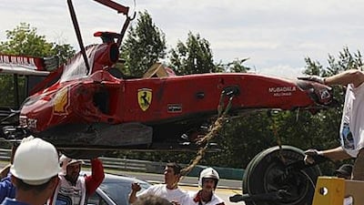 Marshals remove the Ferrari car driven by Felipe Massa after he crashed during the qualification session of the Hungarian Grand Prix at the Hungaroring circuit.