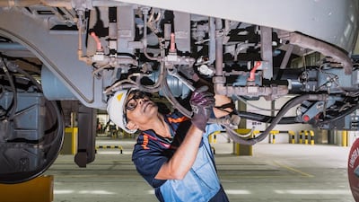 Rolling stock technician Nisath Devage works on the undercarriage of a train at the Dubai Metro depot in Al Qusais. Alex Atack for The National
