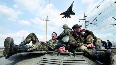 A fighter jet flies overhead as Ukrainian soldiers sit on an armoured personnel carrier in Kramatorsk, in eastern Ukraine, in this April 16 file photo. Marko Djurica / Reuters