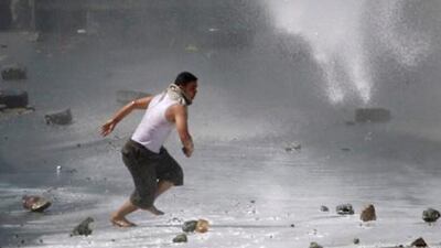 An anti-government protester flees as police use a water cannon to disperse protesters demanding the departure of Yemen's President Ali Abdullah Saleh in the southern city of Taiz yesterday.