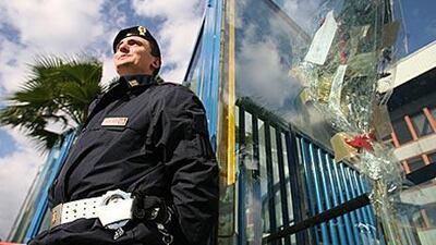 An Italian police officer stands beside flowers left outside the Stadio Angelo Massimino laid in memory of Filippo Raciti, the policeman who died during rioting in 2007.