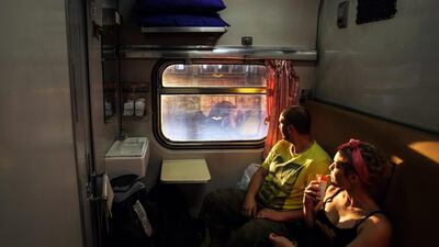 Dutch tourists look out of the window of their first class compartment on the Special Express train, which travels between Bangkok and Chiang Mai. Dario Pignatelli / Bloomberg News