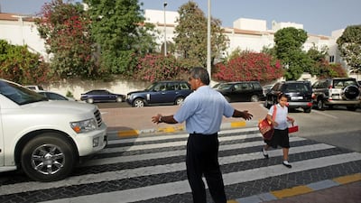 Hassam Kutty, from India, directs traffic to help students and parents arriving at the British School Al Khubeirat. Jaime Puebla / The National