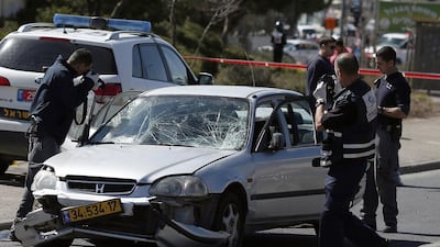 Israeli forensic police inspect a car that ploughed into pedestrians in Jerusalem injuring several people, before its driver got out and tried to stab them, in an attack mirroring similar incidents last year, on March 6, 2015. AFP Photo